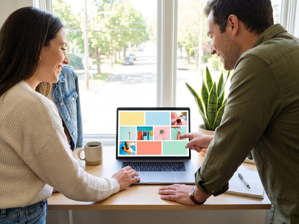 Two coworkers looking at a group card on a laptop